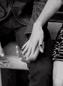 A Black And White Photo Of A Couple Holding Hands . GIF