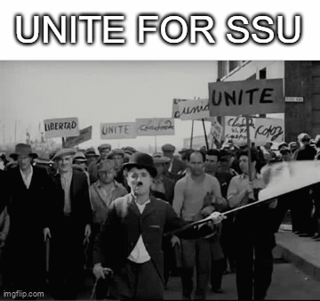 A Black And White Photo Of A Crowd Of People Marching Down A Street Holding Signs . GIF