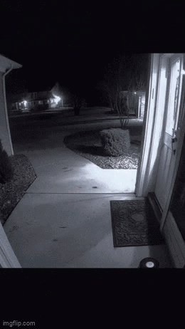 A Black And White Photo Of A Doorway At Night With A Light On . GIF