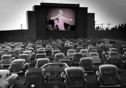 A Black And White Photo Of A Drive-In Theater GIF