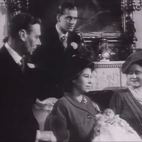 A Black And White Photo Of A Family With A Baby In The Middle GIF
