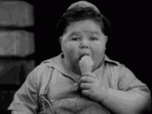 A Black And White Photo Of A Fat Boy Eating A Ice Cream Cone . GIF