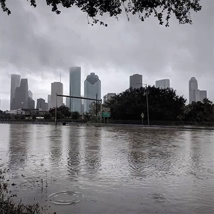 A Black And White Photo Of A Flooded City With The Skyline In The Background . GIF