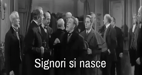 A Black And White Photo Of A Group Of Men Standing In A Room With The Words Signori Si Nasce Written In White . GIF