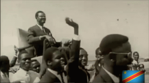 a black and white photo of a group of men with a flag in the corner