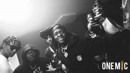 A Black And White Photo Of A Group Of Men With One Wearing A Nfl Hoodie GIF