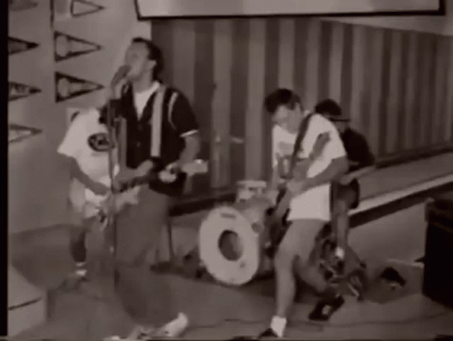 A Black And White Photo Of A Group Of People Playing Instruments . GIF