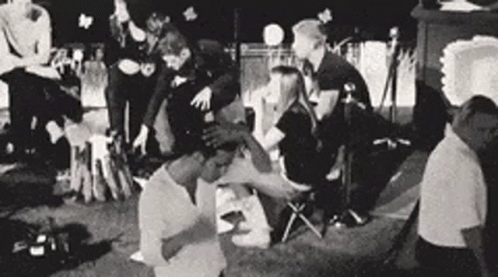 A Black And White Photo Of A Group Of People Sitting In A Circle . GIF