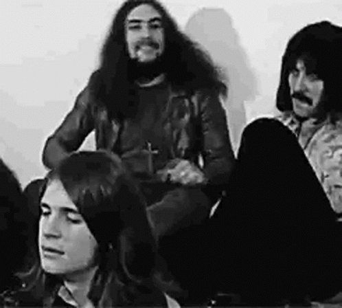 A Black And White Photo Of A Group Of People Sitting On The Floor In A Room . GIF