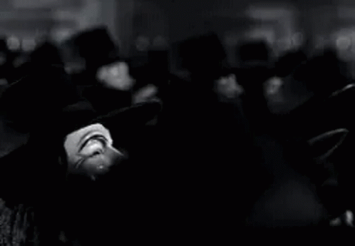 A Black And White Photo Of A Group Of People Wearing Anonymous Masks . GIF