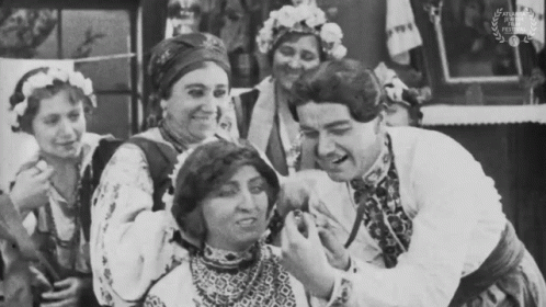 A Black And White Photo Of A Group Of People With A Laurel Wreath In The Corner GIF