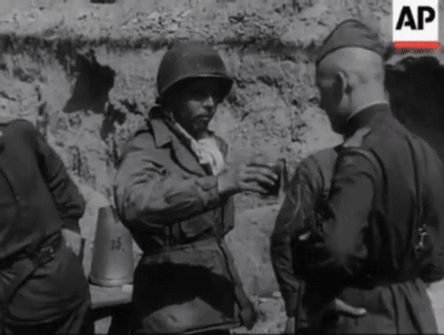 A Black And White Photo Of A Group Of Soldiers Talking . GIF