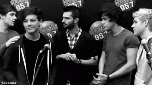 A Black And White Photo Of A Group Of Young Men Shaking Hands . GIF
