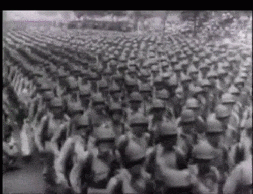 A Black And White Photo Of A Large Army Marching GIF