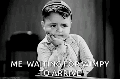 A Black And White Photo Of A Little Boy Sitting At A Desk . GIF