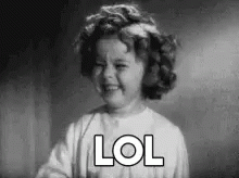 A Black And White Photo Of A Little Girl Laughing With The Word Lol Written On Her Face . GIF