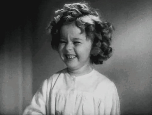 A Black And White Photo Of A Little Girl Laughing . GIF