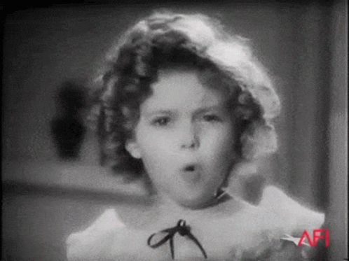 A Black And White Photo Of A Little Girl Making A Funny Face GIF