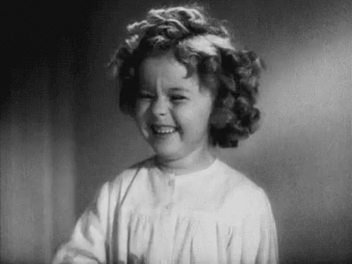 A Black And White Photo Of A Little Girl Smiling . GIF