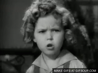 A Black And White Photo Of A Little Girl With Curlers In Her Hair Making A Face . GIF