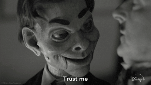 A Black And White Photo Of A Man And A Puppet That Says " Trust Me " GIF