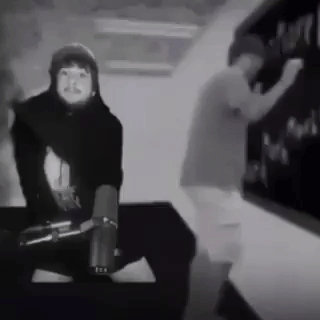 A Black And White Photo Of A Man And A Woman Dancing In Front Of A Chalkboard . GIF