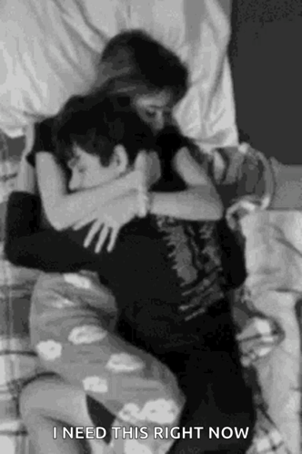 A Black And White Photo Of A Man And A Woman Hugging Each Other . GIF