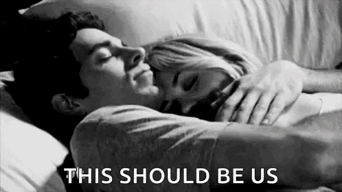 A Black And White Photo Of A Man And A Woman Hugging Each Other In Bed . GIF