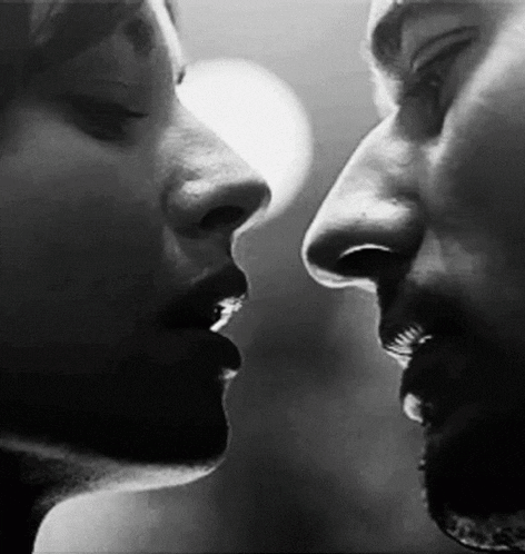 A Black And White Photo Of A Man And A Woman Kissing . GIF