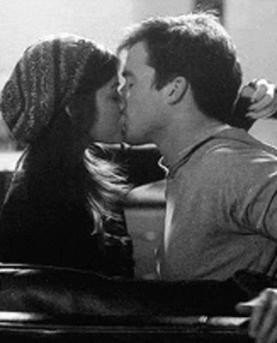 A Black And White Photo Of A Man And A Woman Kissing In A Car . GIF