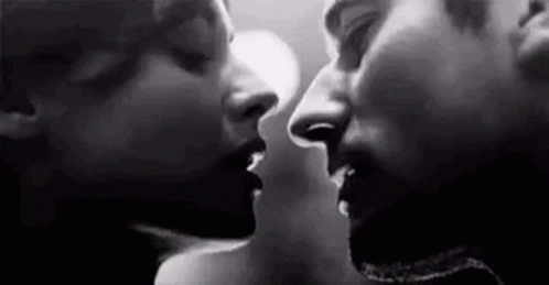 A Black And White Photo Of A Man And A Woman Kissing . GIF