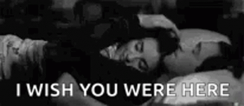 A Black And White Photo Of A Man And A Woman Laying In Bed With The Words `` I Wish You Were Here '' . GIF
