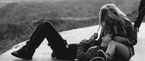 A Black And White Photo Of A Man And A Woman Laying On The Ground GIF
