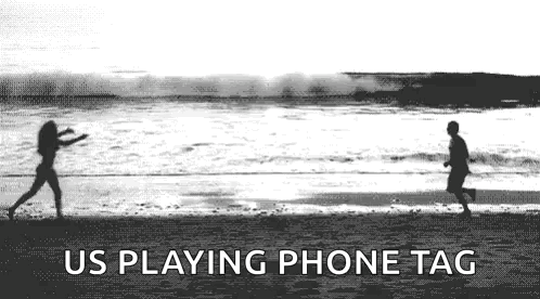 A Black And White Photo Of A Man And A Woman Playing Frisbee On A Beach . GIF