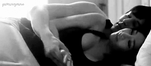 A Black And White Photo Of A Man And A Woman Sleeping In Bed . GIF