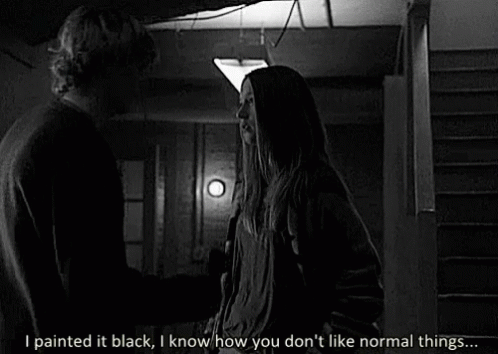 A Black And White Photo Of A Man And A Woman Standing Next To Each Other In A Dark Room . GIF