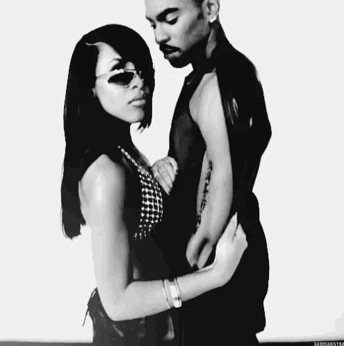 A Black And White Photo Of A Man And Woman Hugging Each Other . GIF