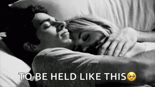 A Black And White Photo Of A Man And Woman Hugging With The Words To Be Held Like This Below Them GIF