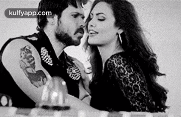 A Black And White Photo Of A Man And Woman Kissing . GIF
