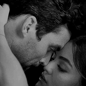 A Black And White Photo Of A Man And Woman Kissing Each Other . GIF