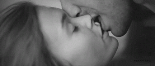 A Black And White Photo Of A Man And Woman Kissing Each Other . GIF