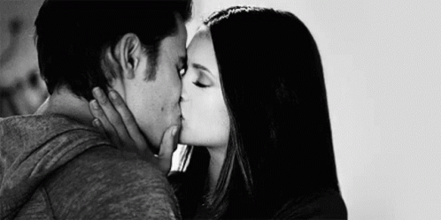 A Black And White Photo Of A Man And Woman Kissing Each Other . GIF