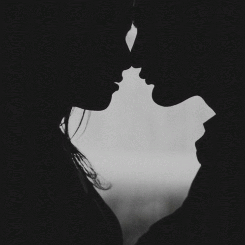 A Black And White Photo Of A Man And Woman Kissing With The Words " A Kiss Goodnight " Below Them GIF