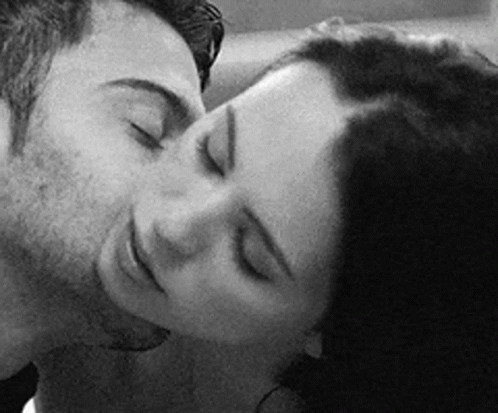 A Black And White Photo Of A Man And Woman Kissing With Their Eyes Closed . GIF