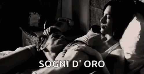 A Black And White Photo Of A Man And Woman Laying In Bed Together . GIF