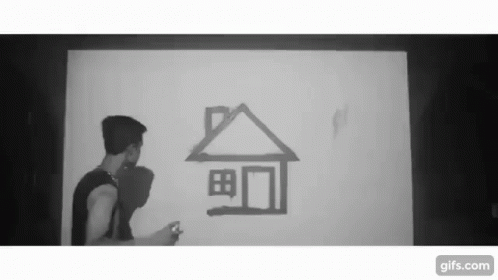 A Black And White Photo Of A Man Drawing A House On A Wall GIF