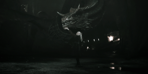 A Black And White Photo Of A Man Holding A Large Dragon GIF