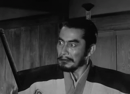 A Black And White Photo Of A Man Holding A Sword GIF