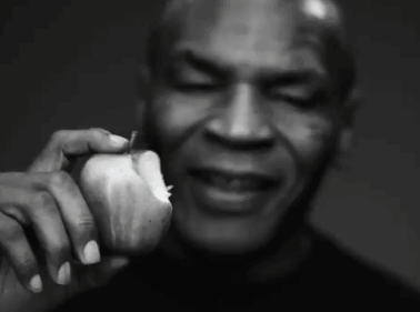a black and white photo of a man holding an apple