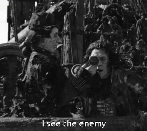 a black and white photo of a man holding binoculars with the words " i see the enemy " below him